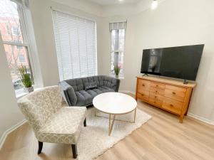 sala de estar con sofá, mesa y TV en Wrigleyville Friends Unit - 5bdrm, en Chicago