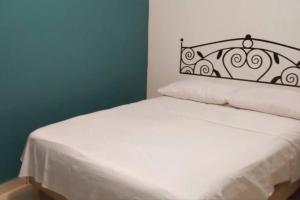 サン・アンドレス・トゥストラにあるNice house Casa de Descanso en San Andrés Tuxtla.のベッドルーム(金属製ヘッドボード付きの白いベッド1台付)