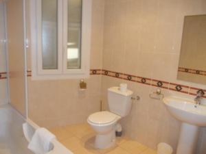 a bathroom with a toilet and a sink at Hotel Marcellin in Beaulieu-sur-Mer