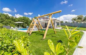 a swing set in a yard with a pool at Lovely Home In Cetinici With Kitchen in Orbanići