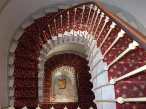a stairway with a spiral staircase with a red wall at Hotel Marcellin in Beaulieu-sur-Mer