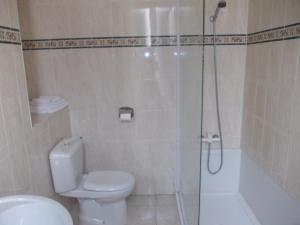 a bathroom with a shower and a toilet and a sink at Hotel Marcellin in Beaulieu-sur-Mer