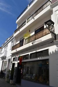 a white building with a balcony on top of it at Hostel Seixe in Odeceixe