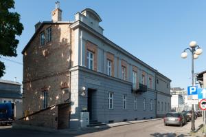 un viejo edificio de ladrillo al lado de una calle en Qbatura Cafe & Hotel, en Ciechanów