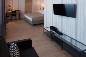 um quarto de hotel com uma cama e uma televisão na parede em Qbatura Cafe & Hotel em Ciechanów