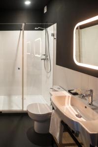 a bathroom with a sink and a shower and a toilet at Qbatura Cafe & Hotel in Ciechanów