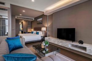 a large living room with a bed and a television at Wyndham Bangkok Queen Convention Centre in Bangkok