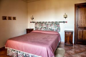 1 dormitorio con 1 cama con colcha roja en Agriturismo Residenza il Girasole, en Bettona