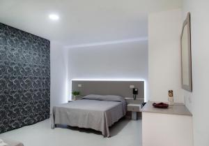 sypialnia z łóżkiem i ścianą w obiekcie Hotel Regina w mieście Caserta