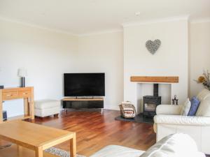 a living room with a fireplace and a tv at Rhos Helyg in Amlwch