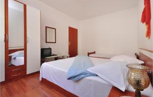ロクヴァ・ロゴズニツァにあるAwesome Apartment In Lokva Rogoznica With 2 Bedroomsのベッドルーム(白いベッド1台、テレビ付)