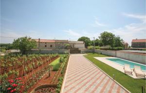 a garden with flowers and a swimming pool and a building at Stunning Home In Cukrici With Wifi in Cukrići