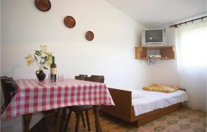 a room with a table and a bed with a bottle of wine at Cozy Apartment In Jadrtovac With House Sea View in Jadrtovac