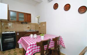 a kitchen with a table with a red and white checkered table cloth at Cozy Apartment In Jadrtovac With House Sea View in Jadrtovac