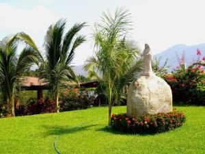 une statue d'un oiseau dans un champ d'herbe dans l'établissement Hotel Paradise Lagoon, à El Coacoyul