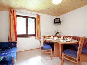 a dining room with a table and chairs and a television at Lush Holiday Home in H ttau near Ski Area in Hüttau