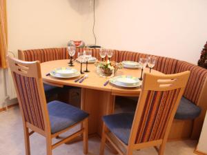 a wooden table with chairs and wine glasses at Lush Holiday Home in H ttau near Ski Area in Hüttau
