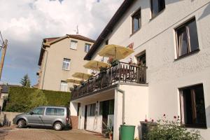 a car parked next to a building with a balcony with umbrellas at Záboj restaurant in Karlovy Vary