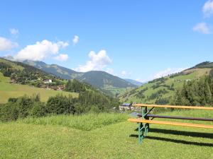 a wooden bench sitting on top of a grassy hill at Modern Apartment near Ski Area in Maria Alm in Maria Alm am Steinernen Meer