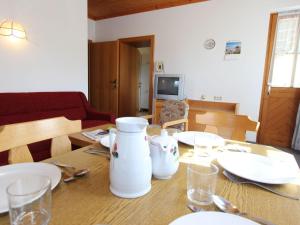 - une table à manger avec des assiettes blanches et des verres dans l'établissement Modern Apartment near Ski Area in Maria Alm, à Maria Alm