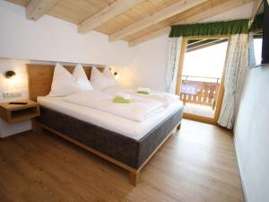 a bedroom with a large bed and a large window at Exquisite vacation apartment in Mittersill near ski area in Mittersill