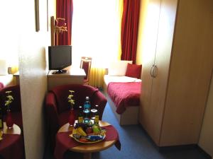 a room with two beds and a table with drinks on it at Hotel am Hauptbahnhof in Schwerin