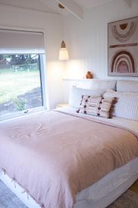 a bedroom with a large white bed with a window at Lakeview Retreat Metung in Metung