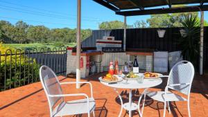 a patio with a table and two chairs and a grill at Bishops Lodge Narrandera in Narrandera