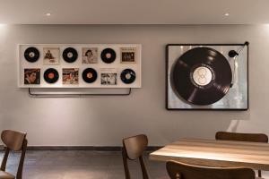 um disco de vinil numa parede com uma mesa e cadeiras em The Moment Hotel Yilan by Lakeshore em Wujie