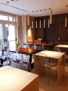 una sala da pranzo con tavoli, sedie e lampadari a braccio di La Castellana Loft Hotel a Bergamo