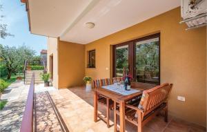 a patio with a wooden table and chairs at Stunning Apartment In Umag With 1 Bedrooms And Wifi in Umag