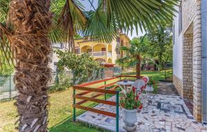 a house with a table and a palm tree at Amazing Apartment In Porec With Wifi in Poreč