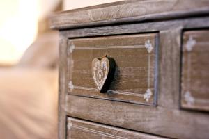 een houten lade met een hart erop bij Chambre Le Hupsa Pfannala in Saint-Hippolyte
