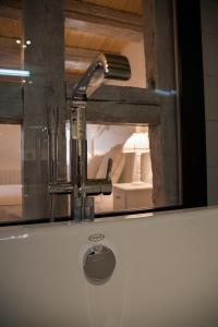 a bathroom sink with a faucet and a mirror at Chambre Le Hupsa Pfannala in Saint-Hippolyte