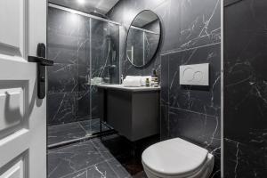 a black bathroom with a toilet and a mirror at Best Stay Jeuneurs in Paris