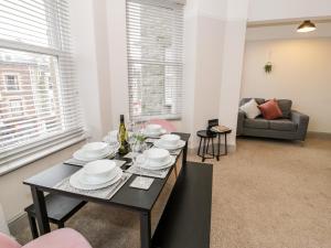 a dining room with a table and chairs and a couch at Rose Suite in Barmouth