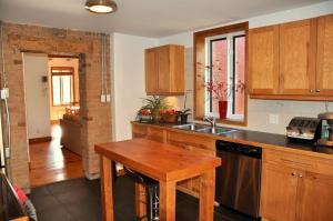 a kitchen with wooden cabinets and a wooden table at Le Tierra del Fuego by HomeInMontreal in Montreal