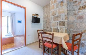 a dining room with a table and a stone wall at Awesome Apartment In Svinisce With Kitchenette in Svinišće