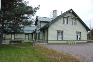 a large green house with a brick driveway at Avinurme Hostel in Avinurme