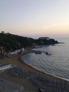 una spiaggia con sedie blu e l'oceano di Appartamenti Torre Medicea a Castiglioncello