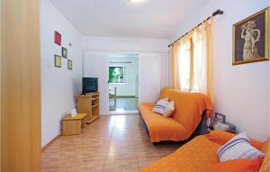 a living room with an orange couch and a television at Lovely Apartment In Sucuraj With Wifi in Sućuraj