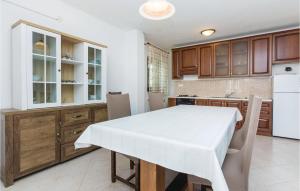uma cozinha com uma mesa com uma toalha de mesa branca em Pet Friendly Home In Privlaka With Wifi em Privlaka