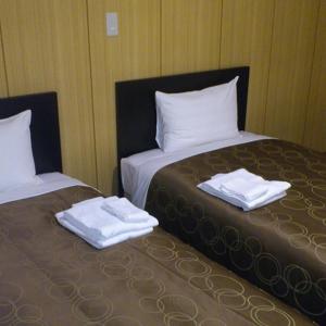 - 2 lits dans une chambre avec des serviettes dans l'établissement Select Inn Hamamatsu Ekimae, à Hamamatsu