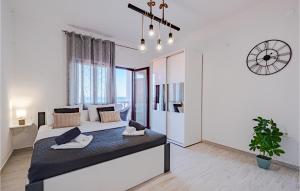 a bedroom with a large bed and a clock on the wall at Beautiful Apartment In Prigradica With Wifi in Prigradica