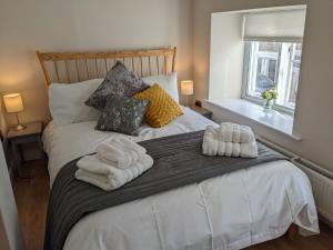 a bedroom with a bed with towels on it at Troopers Cottage in Frome