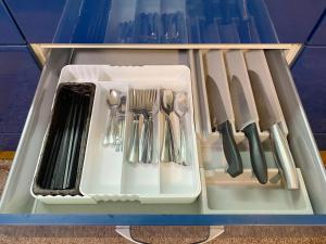 a plastic container with utensils in a drawer at House COCOA in Hakodate