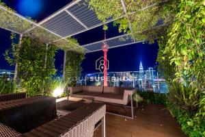 une terrasse sur le toit avec un banc et un panorama de la ville la nuit dans l'établissement Ceylonz Suites nr Pavilion & KLCC by YourSuperhost, à Kuala Lumpur 17 autres photos