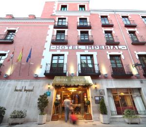 un hombre caminando delante de un edificio en Hotel Imperial en Valladolid