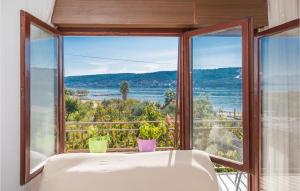a bath tub in front of a window with a view at Beautiful Apartment In Trogir With Wifi in Trogir