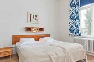 1 dormitorio con 2 camas con sábanas blancas y ventana en Värdshuset Engelbrekt, en Norberg